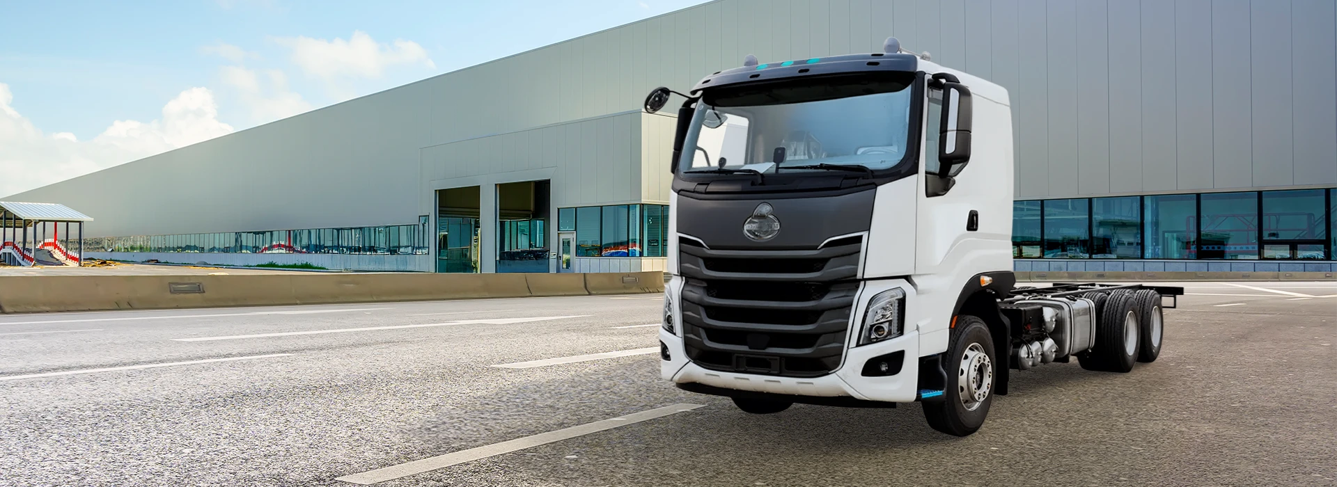 White Chenglong H7 6x2R cargo truck cab chassis outside a warehouse.