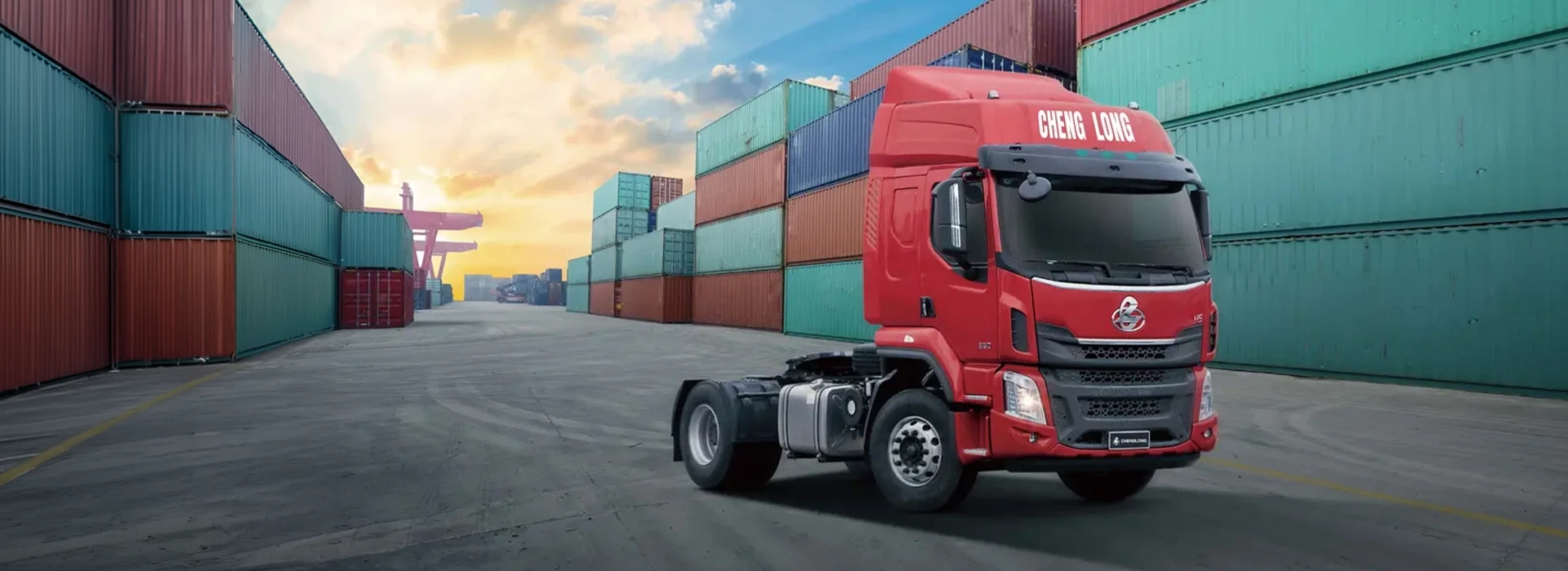 Red Chenglong 4x2 H5 tractor truck at a shipping container terminal for commercial transport and logistics