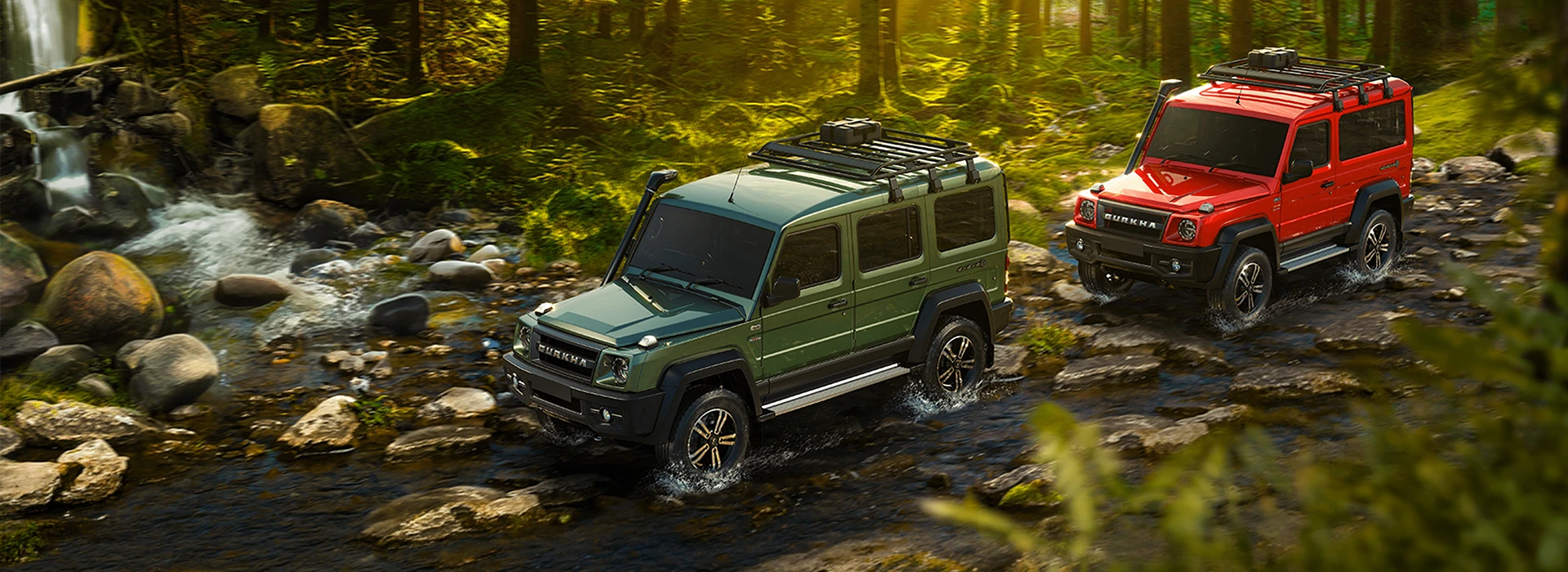 Green and red Force Gurkha 4x4 off-road SUVs equipped with roof racks and snorkels navigating a shallow, rocky riverbed in a sunlit forest
