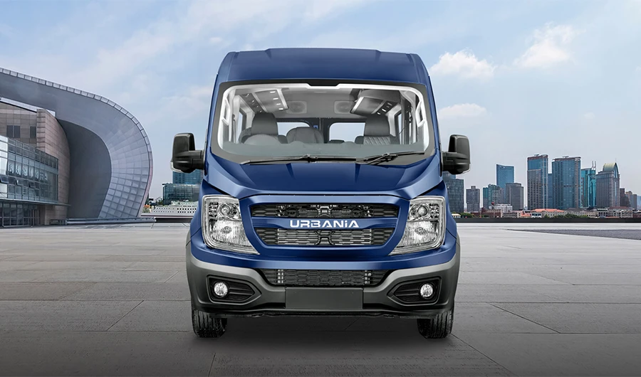 Front view of a dark blue Force Motors Urbania luxury van set against modern city skyscrapers