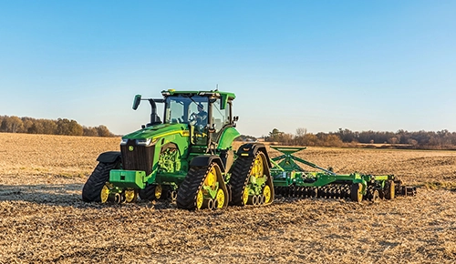 John Deere 8RX Series quad track agricultural tractor pulling farm equipment