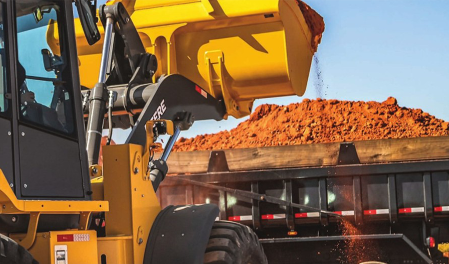 John Deere wheel loader loading earth into a dump truck at a construction site