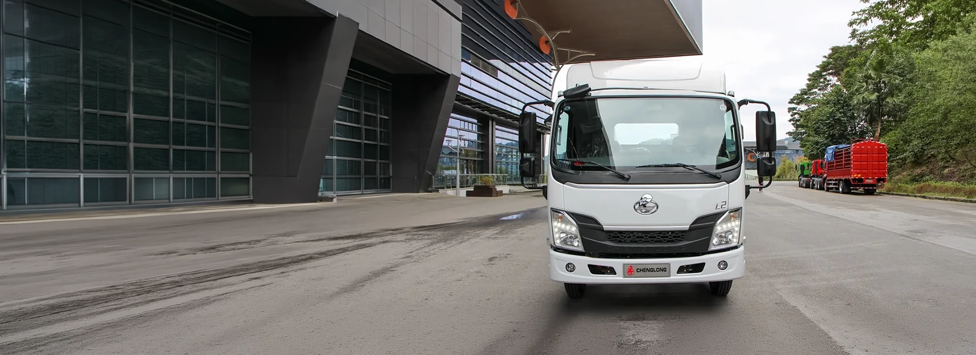 Chenglong L2 light-duty truck parked outside a modern commercial building.