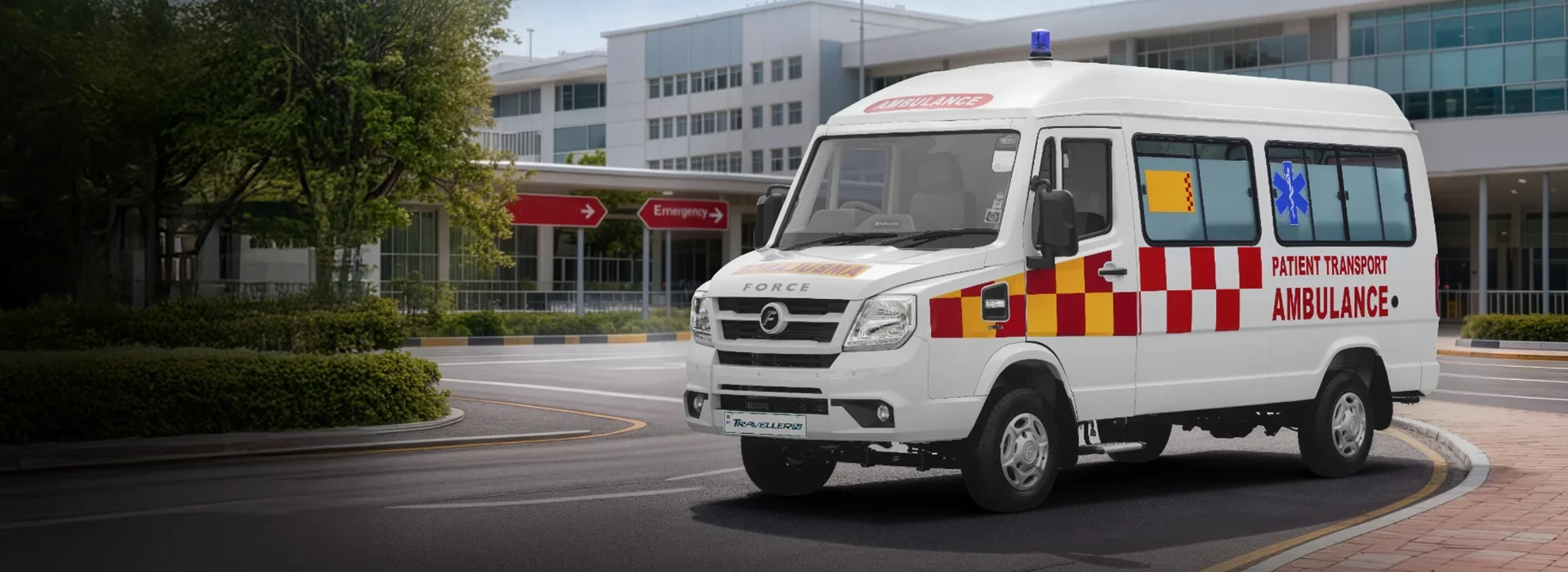 White Force Traveller patient transport ambulance parked outside a modern hospital emergency entrance.