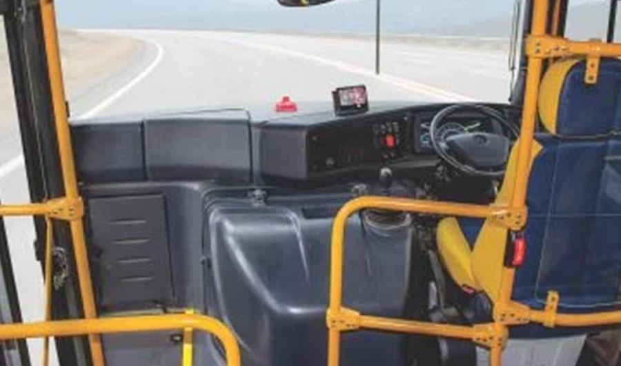 Force Monobus school bus driver cockpit showing steering wheel, dashboard, driver seat and safety handrails