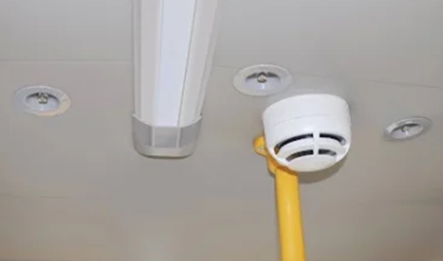 School bus interior ceiling fitted with safety device, overhead lighting and yellow handrail