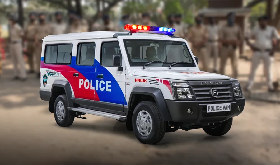 White Force Trax Toofan Hawk police patrol van featuring red and blue side decals and a roof-mounted LED emergency siren lightbar