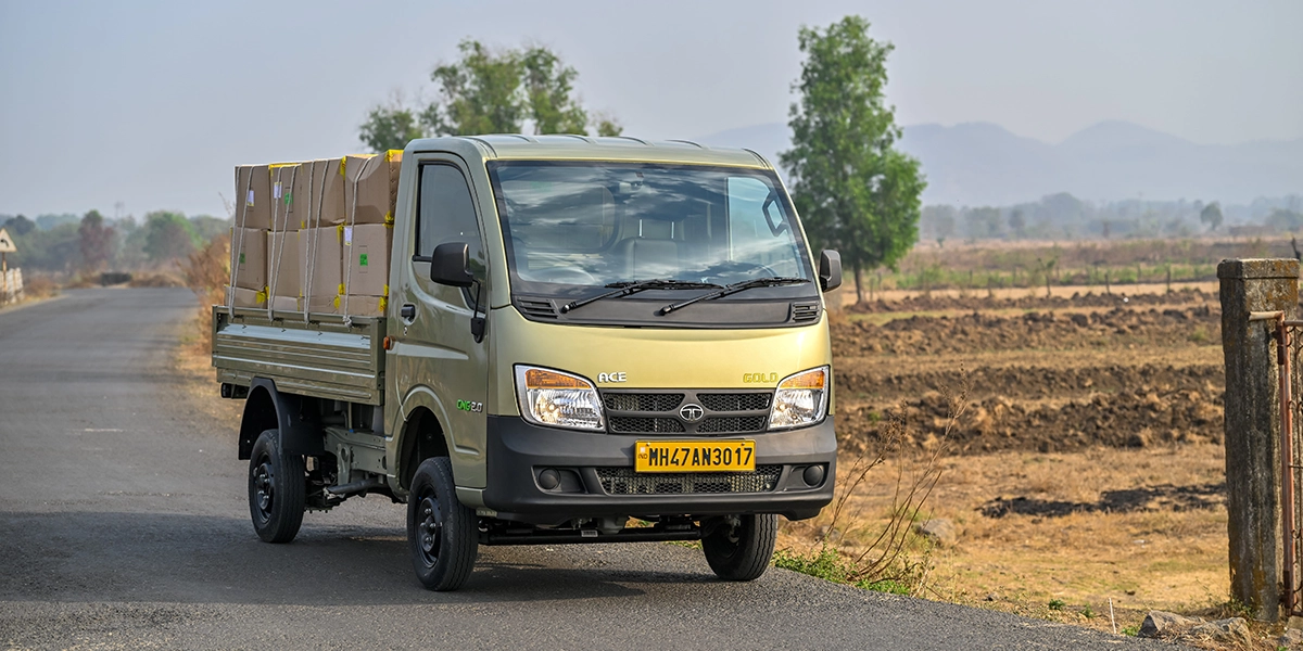 Gold Tata Ace Gold CNG 2.0 truck carrying cardboard boxes on a rural road