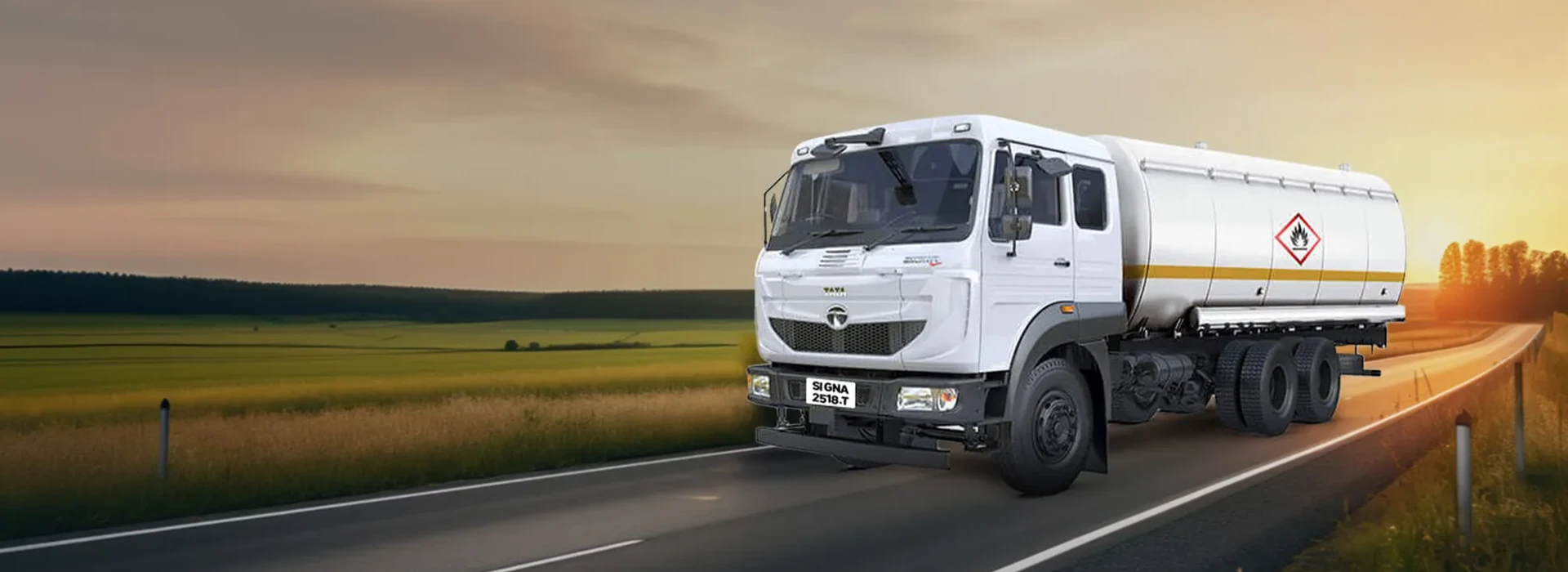 White Tata Signa 2518.T tanker truck driving on a country road at sunset.