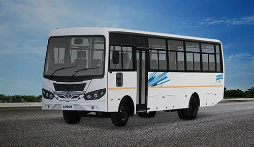 White Tata LP 909 passenger bus parked on an open road against a blue sky