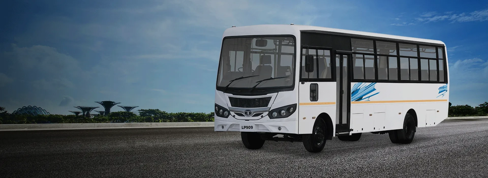 White Tata LP 909 passenger bus parked on an open road against a blue sky