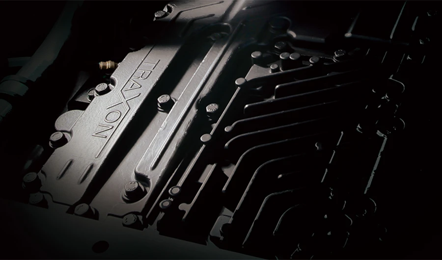 Close-up view of a dark grey ZF TraXon transmission housing showing embossed TraXon branding under accent lighting.