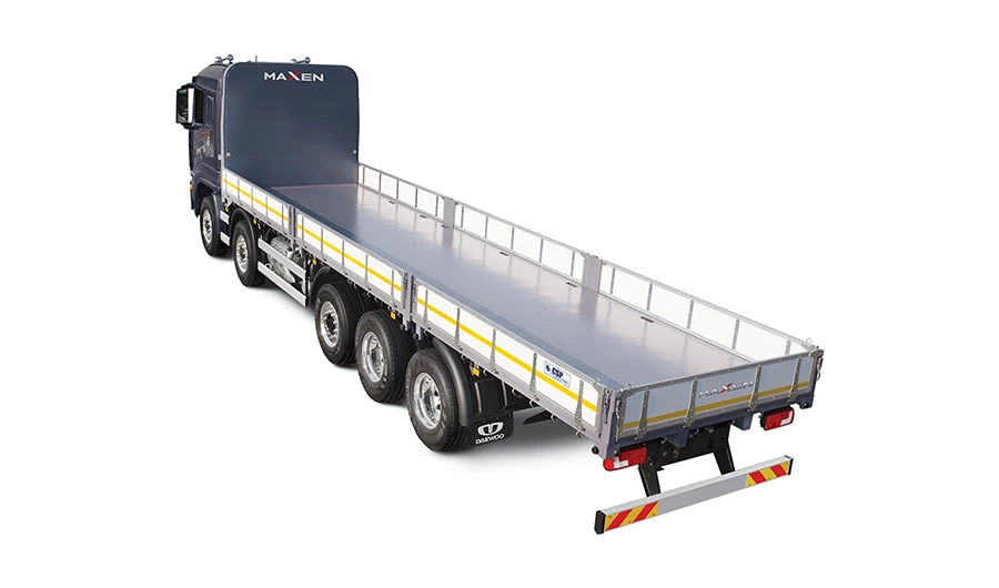 Elevated rear three-quarter view of a multi-axle Daewoo Maxen drop-side flatbed commercial truck on a white background.