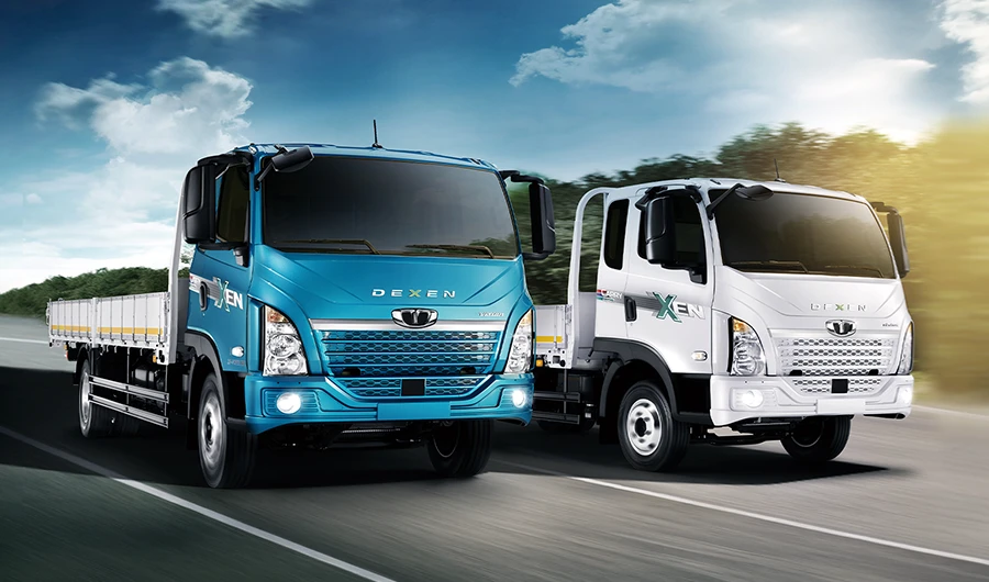 Teal blue and white Daewoo Dexen flatbed trucks driving along an open highway