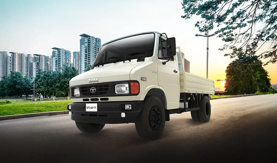 Cream-colored Tata SFC 407 TT light commercial truck parked with city skyline in background