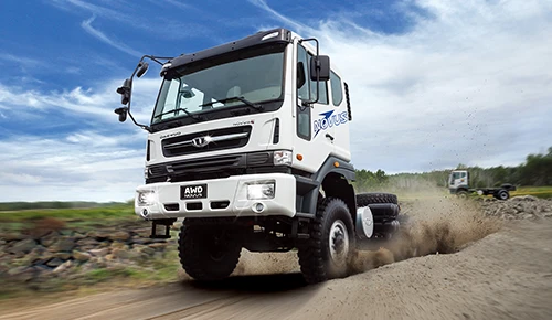White Daewoo Novus AWD off-road truck driving on a dirt road kicking up dust
