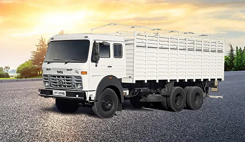 y Recommendation: alt="White Tata LPT 2516 multi-axle haulage truck with high-sided cargo body at sunset