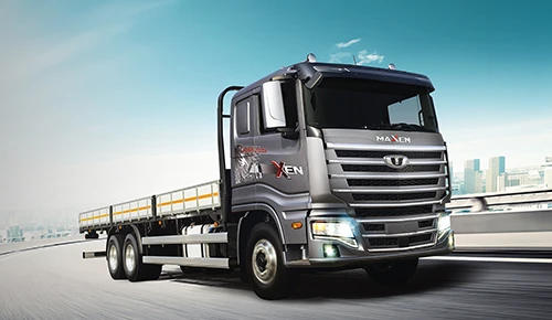 Metallic silver Daewoo Maxen heavy-duty flatbed truck driving on an elevated highway