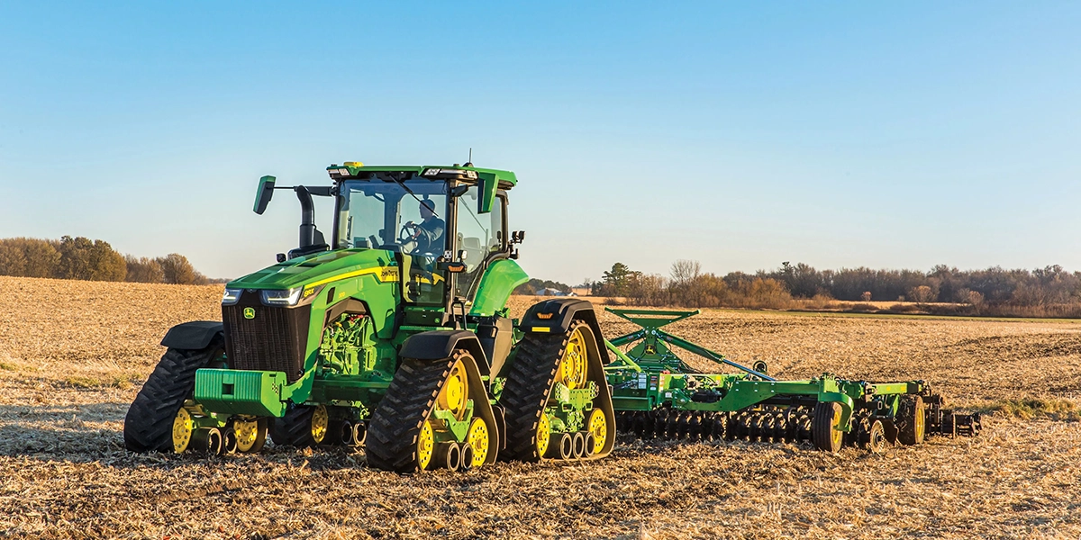 John Deere 8RX Series quad track agricultural tractor pulling farm equipment