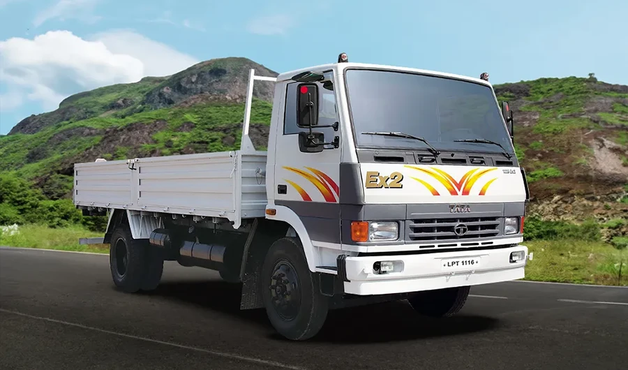 Front three-quarter angle of white Tata LPT 1116 EX2 truck against green hills