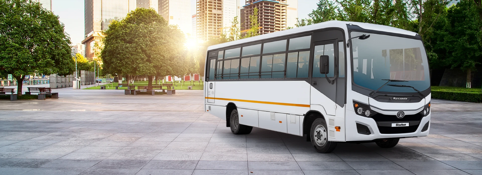 White Tata LP 913 52 passenger bus showcased on a paved city plaza with modern high-rise buildings in the background.