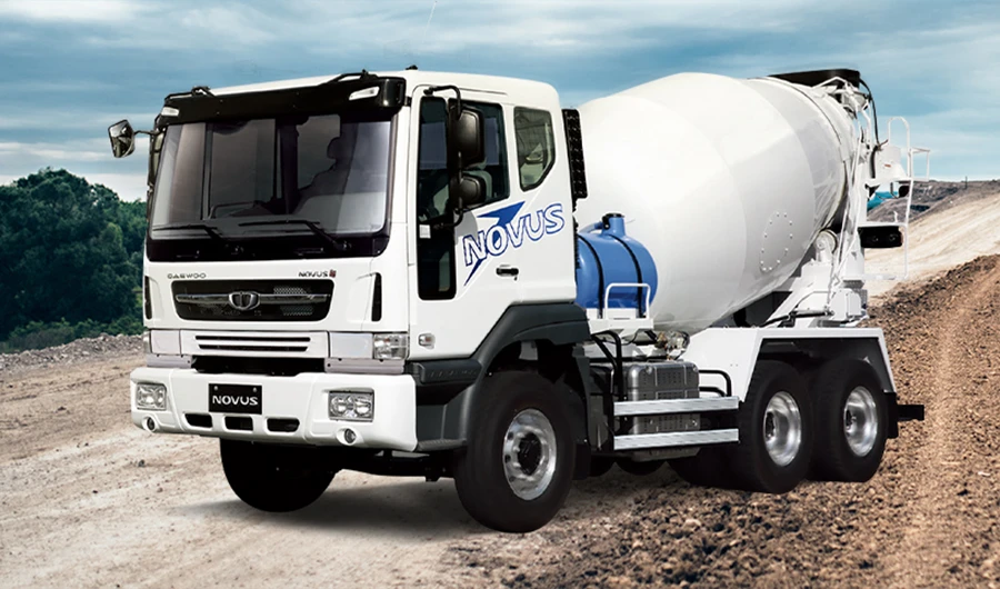 White Daewoo Novus concrete mixer truck parked on a dirt construction site