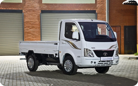 White Tata Super Ace light commercial truck with dropside flatbed parked outside a warehouse