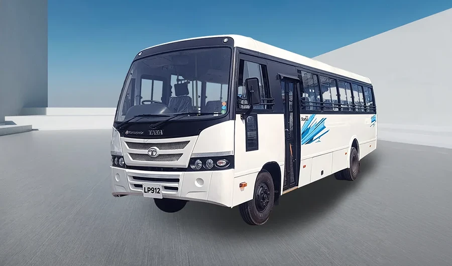 White Tata LP 912 passenger bus parked on a studio platform against a bright blue sky