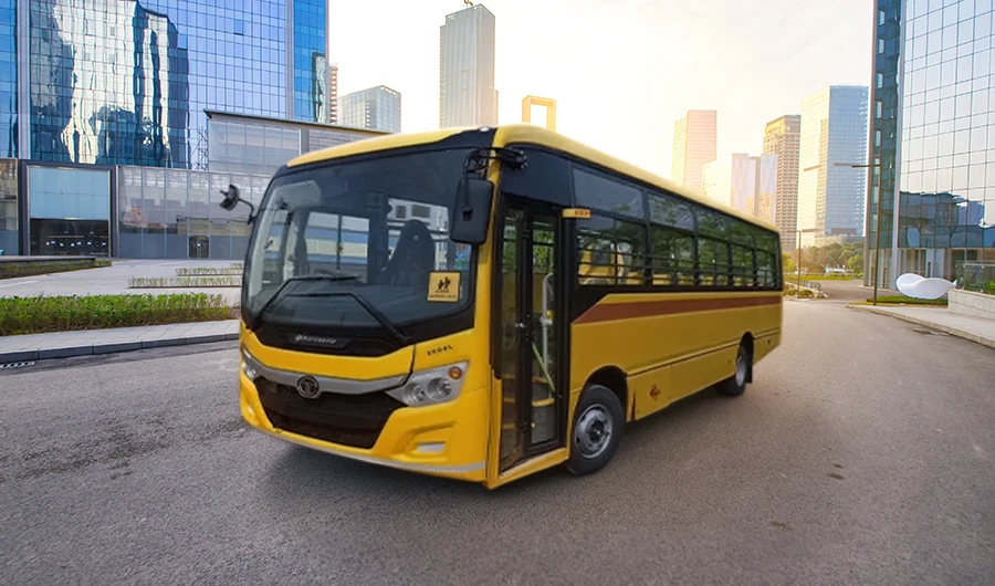 Yellow Tata Starbus Ultra School LPO 8.6/44 bus driving on a multi-lane city road with skyscrapers in the background