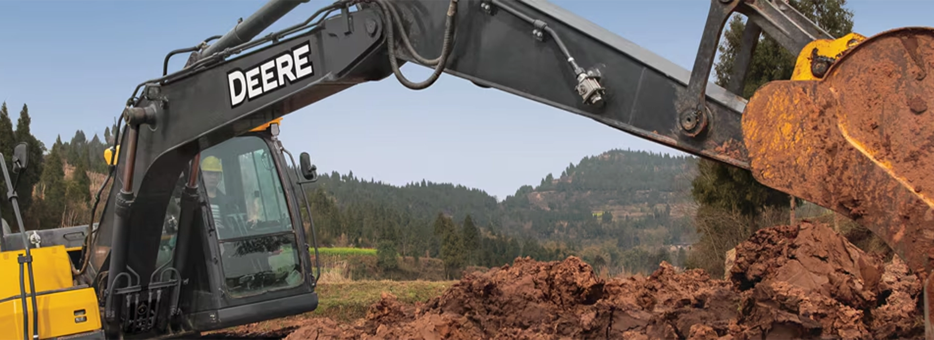 John Deere excavator digging and moving earth at a construction site
