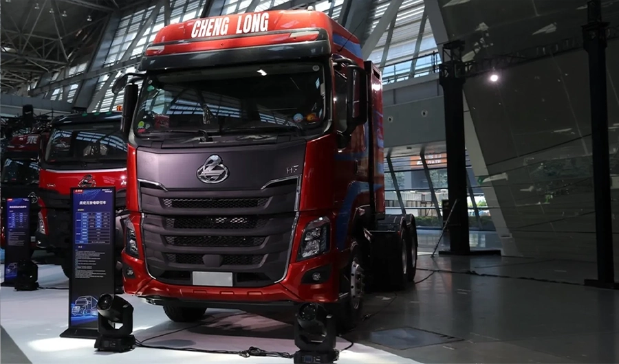 Red Chenglong H7 heavy-duty electric tractor truck displayed at a commercial vehicle exhibition
