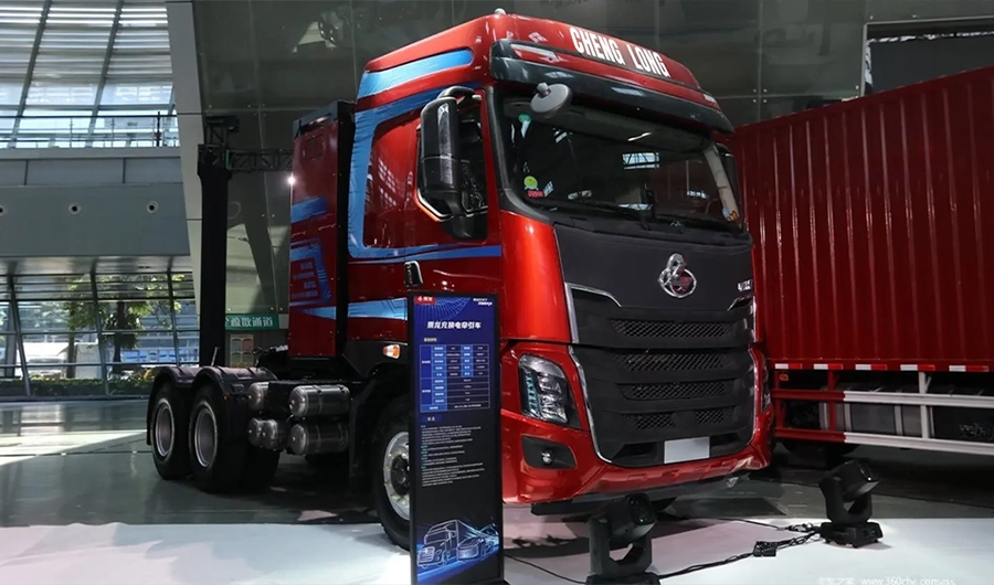 Red Chenglong heavy-duty 6x4 electric tractor truck displayed at a commercial vehicle exhibition