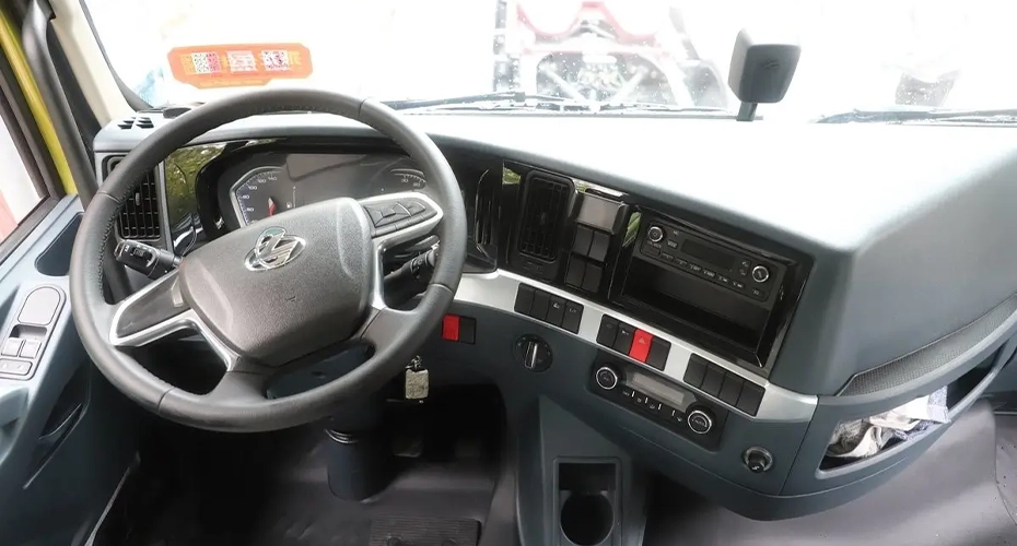 Chenglong heavy-duty truck cab interior showing steering wheel, instrument cluster, dashboard controls and centre console